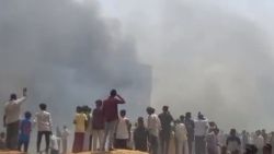 People watch smoke rising after an airplane crashed in Ahmedabad, Gujarat state, India, Thursday, June 12, 2025. (Mohan Nakum via AP)