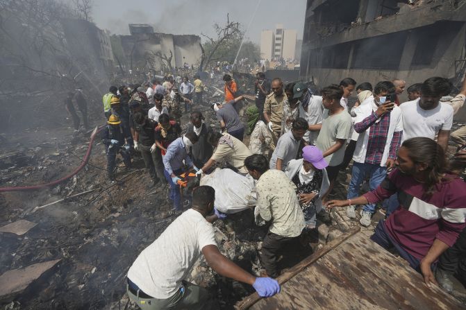 Rescuers carry a victim's body.