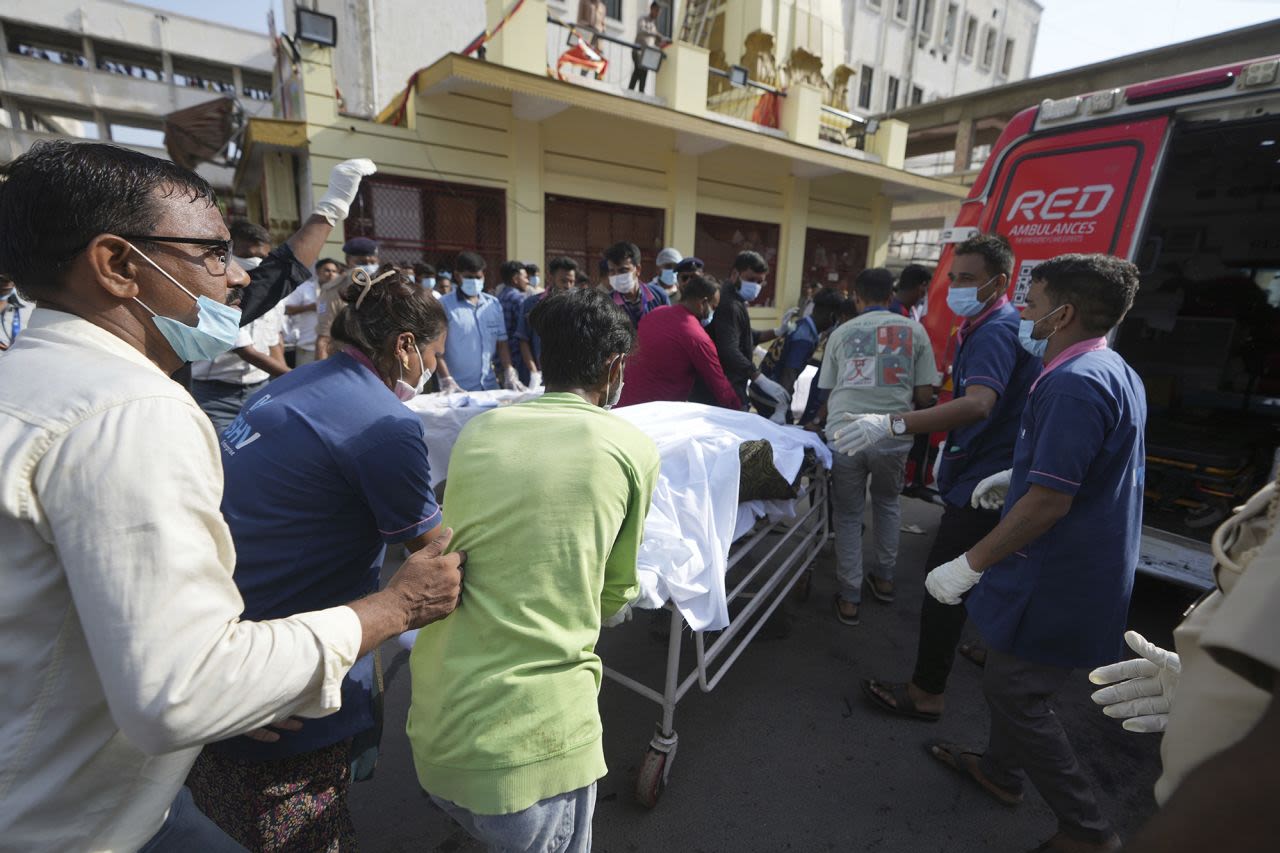 El cuerpo de una víctima es trasladado a un hospital tras el accidente aéreo ocurrido este jueves en la ciudad de Ahmedabad, en el noroeste de India, en el estado de Gujarat.