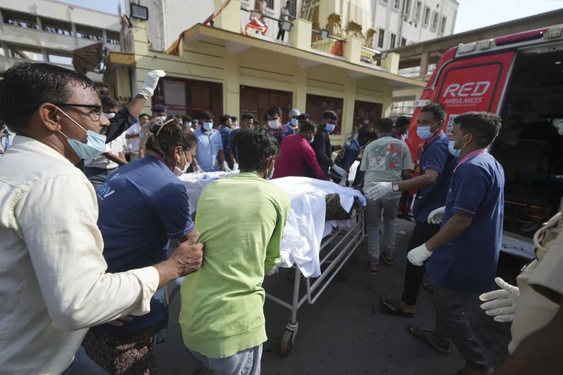 El cuerpo de una víctima es trasladado en camilla a una ambulancia cerca del lugar del accidente.