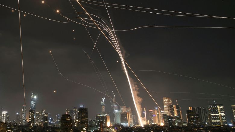A projectile hits buildings as the Israeli Iron Dome air defense system fires to intercept missiles over Tel Aviv, Israel, on Friday, June 13.