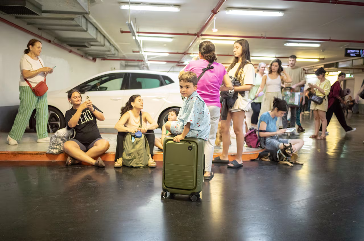 People seek shelter as sirens sound during a missile strike in Ramat Gan, near Tel Aviv early Saturday.