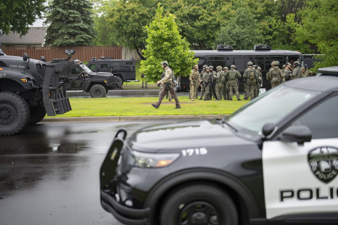 Law enforcement officers, including local police, sheriffs and the FBI, stage less than a mile from a shooting in Brooklyn Park, Minnesota, on June 14, 2025.