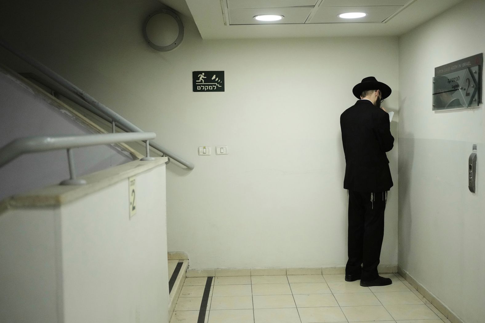 A Jewish man prays as he takes shelter during sirens warning of incoming fire in Jerusalem on Saturday, June 14.