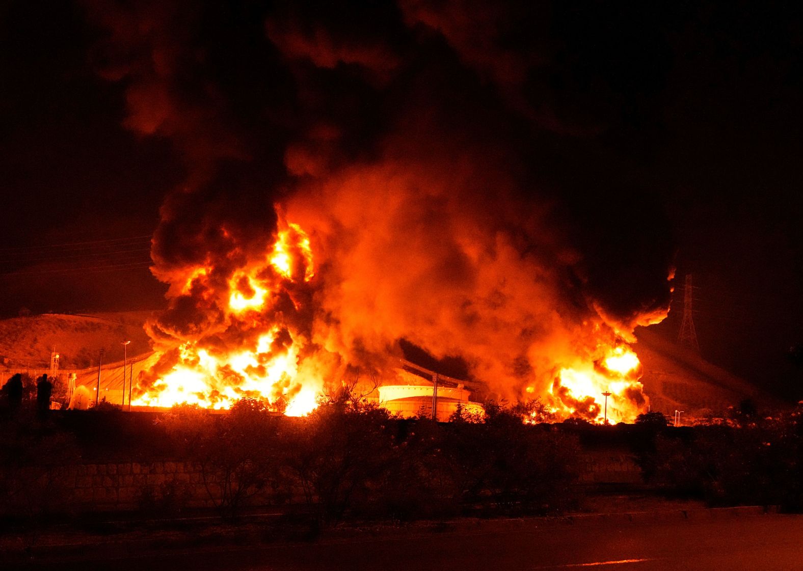 Flames rise from an oil storage facility after it was struck by an Israeli missile in Tehran early Sunday.