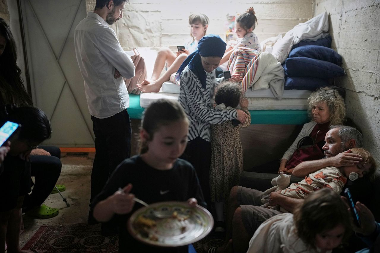 People take shelter in a basement as a siren sounds a warning following missile launches from Iran in Jerusalem on Sunday.