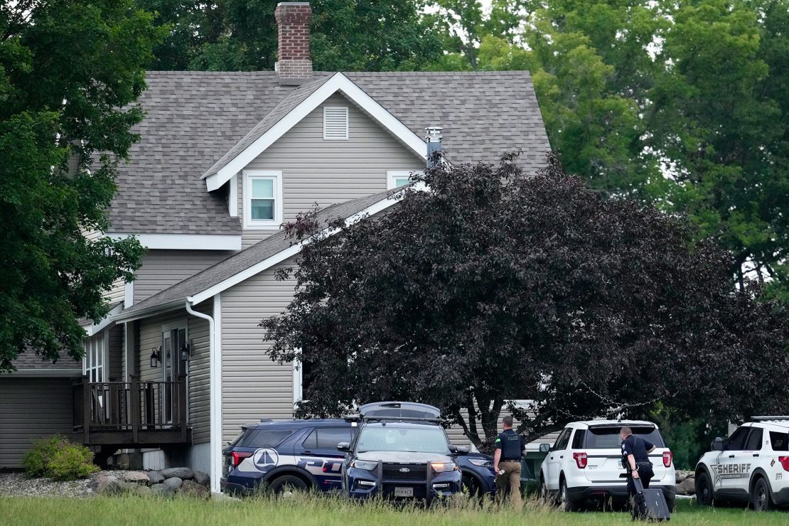 Law enforcement officers investigate the home of shooting suspect Vance Boelter on Sunday in Green Isle, Minnesota.