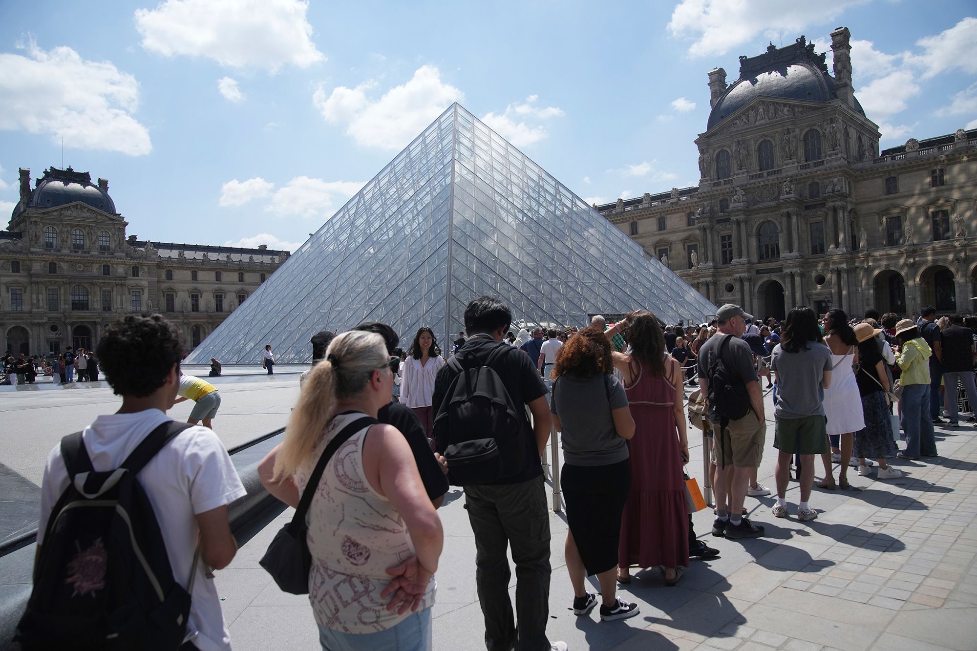 Tourists wait outside the Louvre museum in Paris, which failed to open Monday.