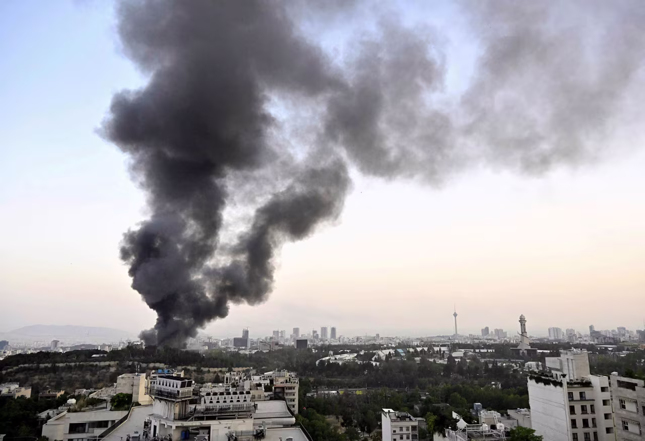 Black smoke billows from the headquarters of Iranian state television in Tehran following an Israeli attack on June 16, 2025.