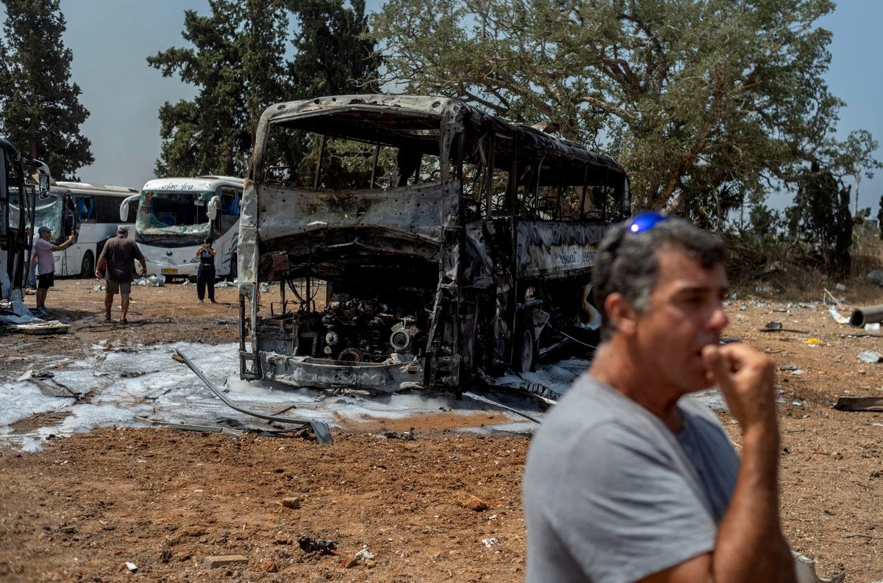 Un hombre se encuentra frente a un autobús dañado por un misil iraní en Herzliya, Israel, este martes.