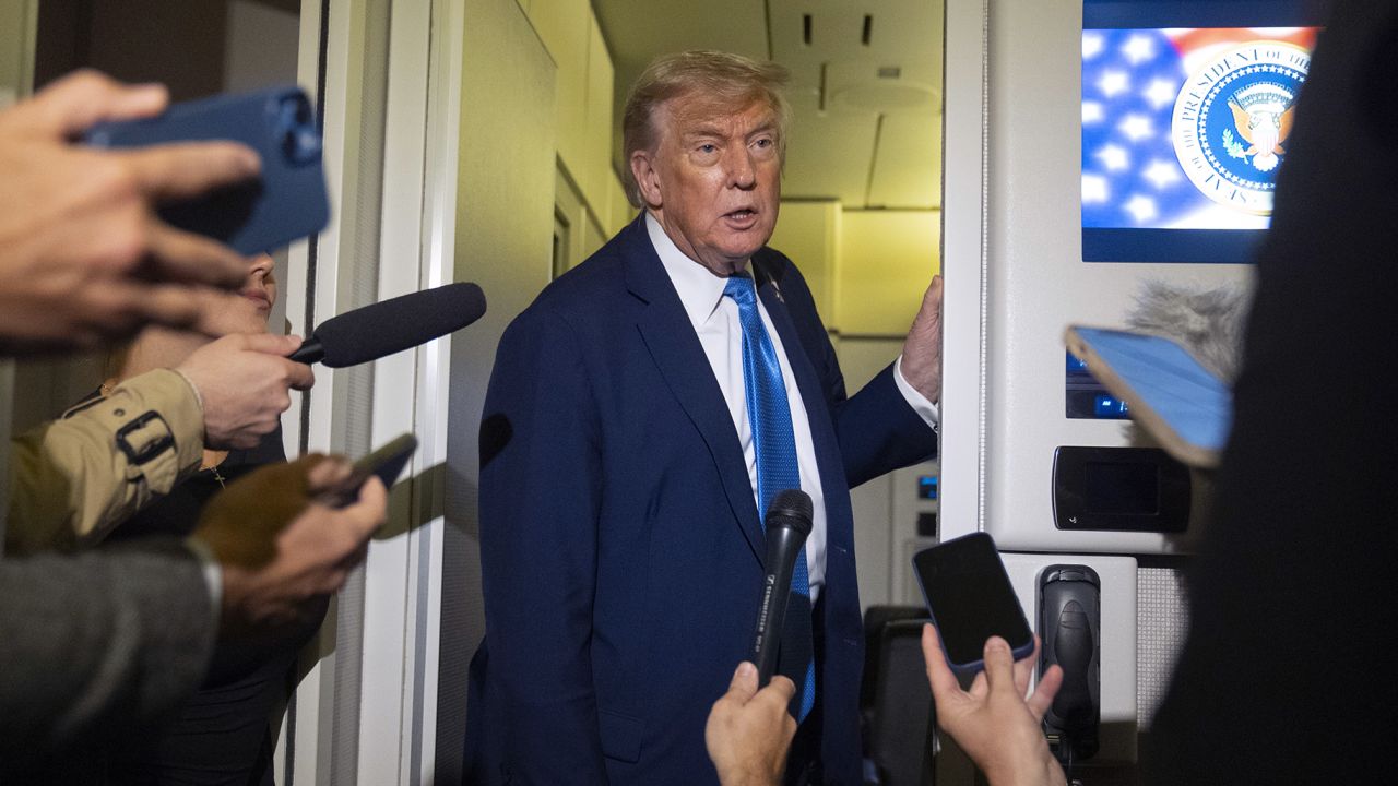 President Donald Trump speaks with reporters while flying aboard Air Force One en route from Calgary, Canada to Joint Base Andrews on Monday.