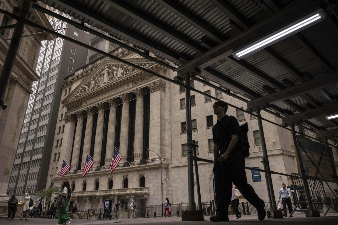 People walk past the New York Stock Exchange on June 18 in New York.