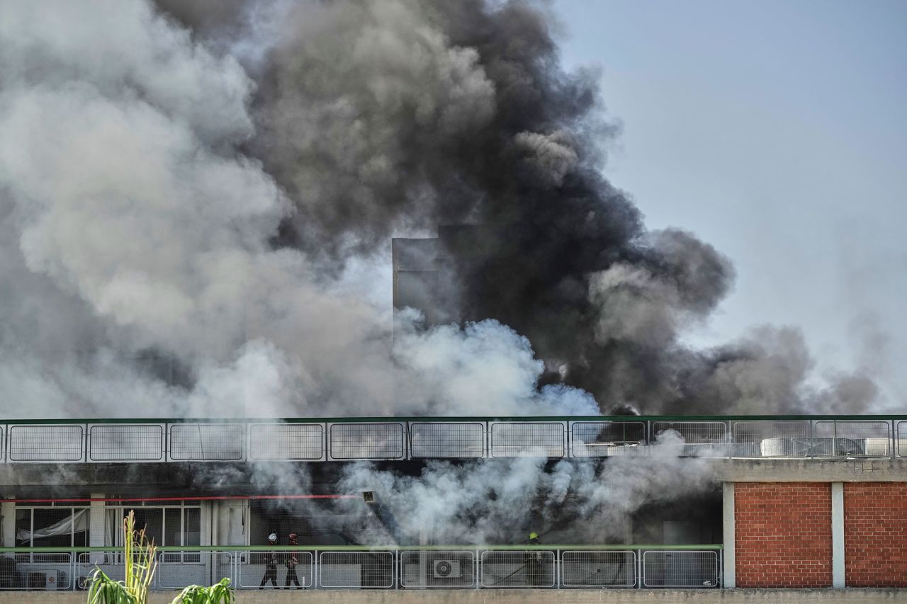 Firefighters work in a building of the Soroka hospital complex in Beer Sheva, after it was hit by a missile.