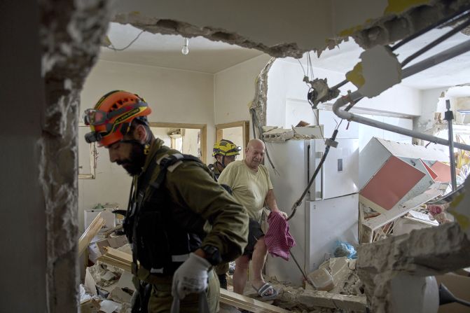 An Israeli rescue team evacuates Haim Rasin from his apartment after it was destroyed by an Iranian missile strike in Ramat Gan.