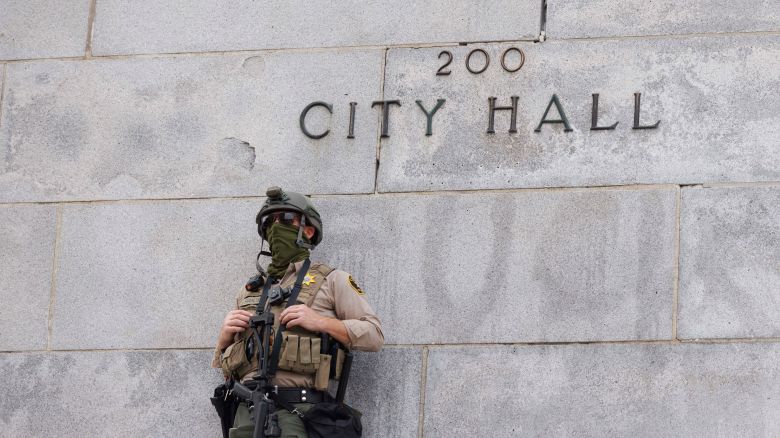 A law enforcement officer stands as people filled the streets of downtown Los Angeles in a massive 'No Kings' march, starting at City Hall and Molina Park.