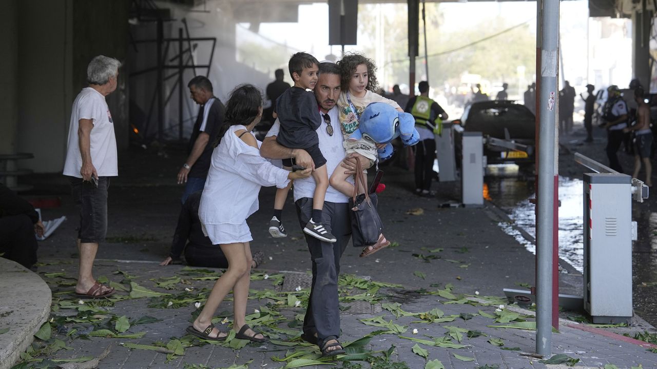 People evacuate after a missile launched from Iran struck in Haifa, Israel, Friday, June 20, 2025. (AP Photo/Baz Ratner)