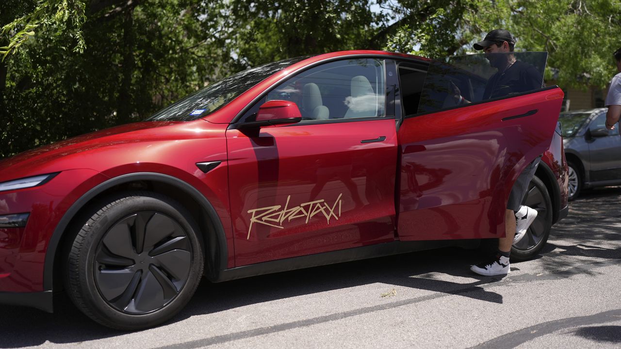 A rider boards a driverless Tesla robotaxi, a ride-booking service, Sunday, June 22, 2025, in Austin, Texas. (AP Photo/Eric Gay)