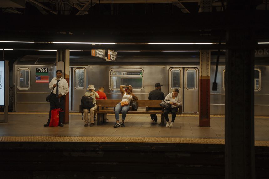 Passengers wait for the train on a subway platform during a heat wave on June 24.