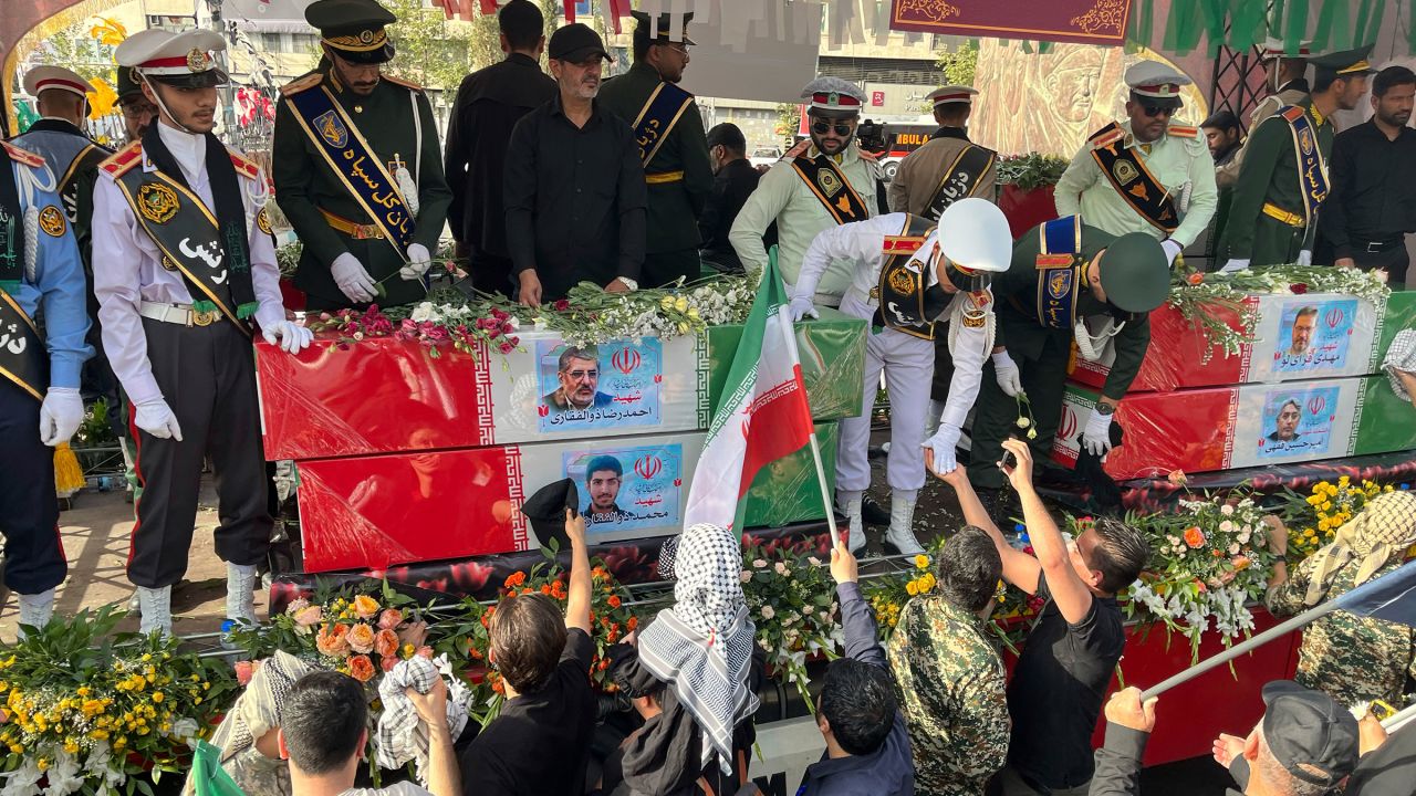 People mourn over the flag-draped coffins of Iranian nuclear scientists who were killed in Israeli strikes, during a funeral ceremony in Tehran. Iran, Saturday, June 28, 2025. (AP Photo/Vahid Salemi)