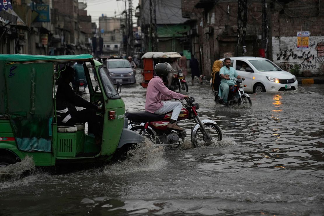 Motorists drive through a flooded road caused by heavy monsoon rains, in Lahore, Pakistan, Sunday, June 29, 2025.