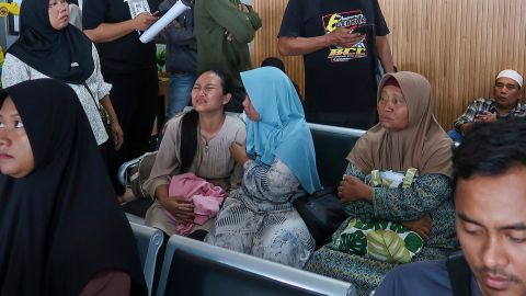 A passenger's relative weeps after a ferry carrying dozens of passengers sank near the resort island of Bali, at Ketapang Port in Bayuwangi, East Java, Indonesia, on Thursday, July 3, 2025.