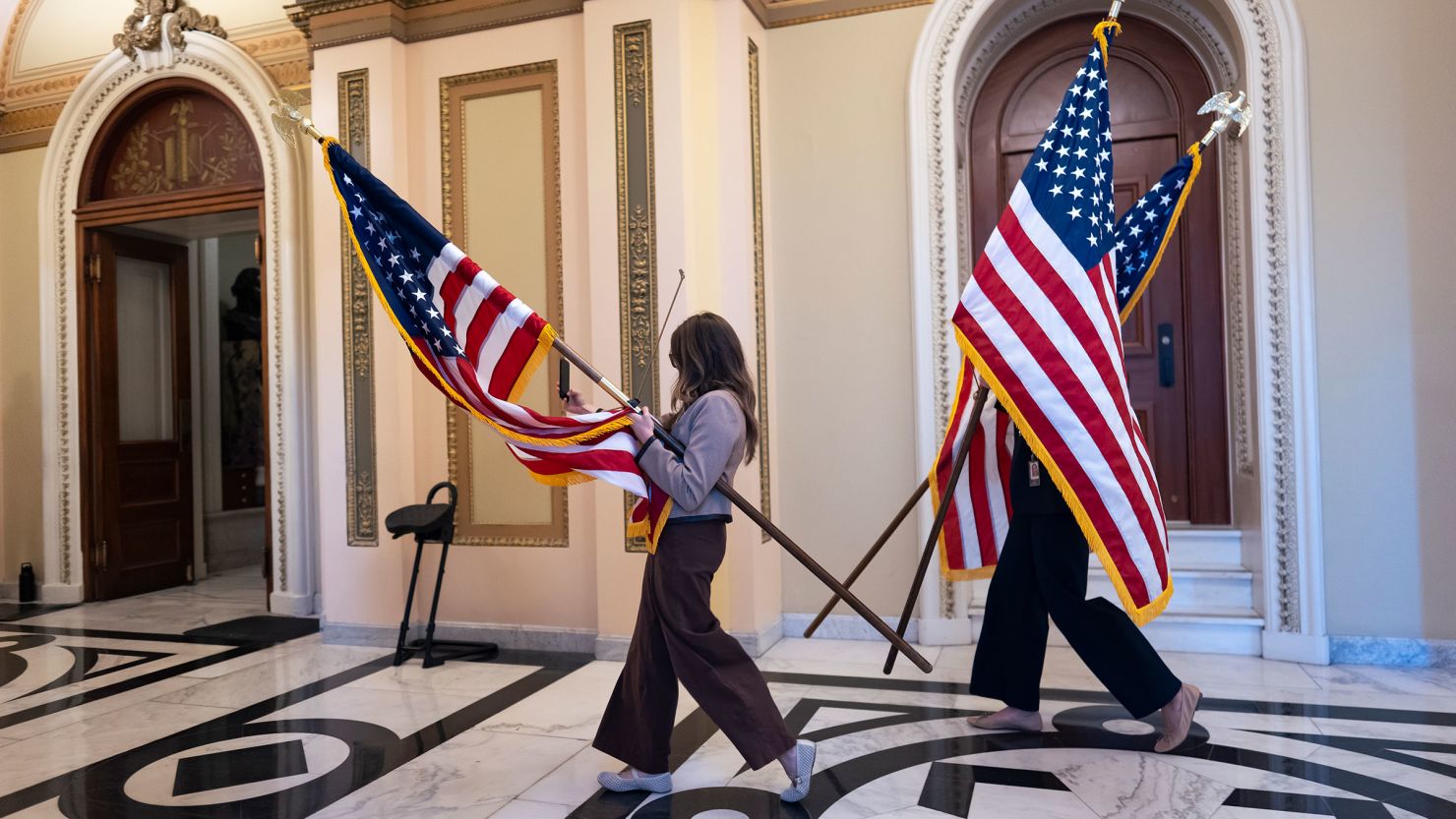 House staffers carry American flags to be used for a ceremony with House Speaker Mike Johnson, after final passage of President Donald Trump's sweeping domestic policy bill at the US Capitol on Thursday.
