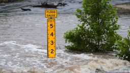 A flood gauge marks the height of water flowing over a farm-to-market road near Kerrville, Texas, on Friday, July 4, 2025. (AP Photo/Eric Gay)