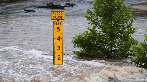 A flood gauge marks the height of water flowing over a farm-to-market road near Kerrville, Texas, on Friday, July 4, 2025. (AP Photo/Eric Gay)