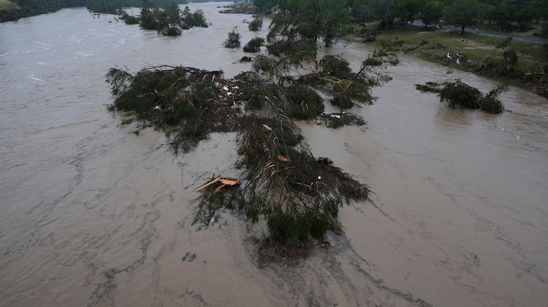 A raging Guadalupe River leaves fallen trees and debris in its wake, on Friday, July 4, in Kerrville, Texas.