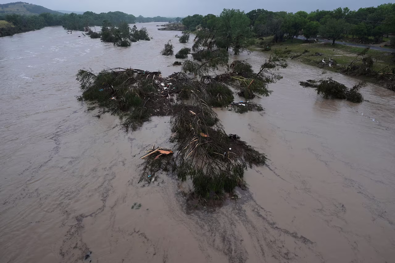 A raging Guadalupe River leaves fallen trees and debris in its wake, on Friday, July 4, in Kerrville, Texas.