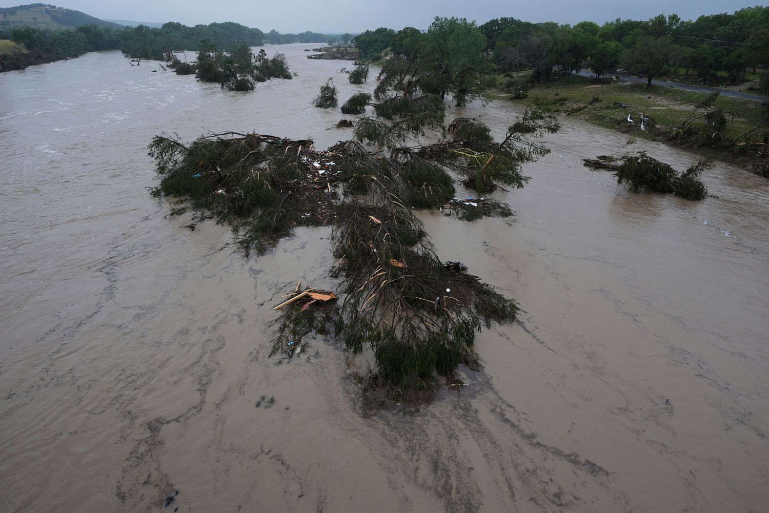 A flooding Guadalupe River, seen in Kerrville, Texas, leaves fallen trees and debris in its wake on Friday.