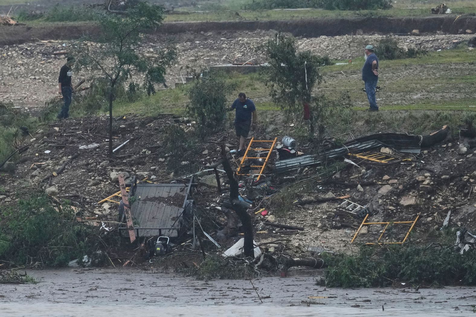 Men survey damage left by the flooded Guadalupe River in Kerrville.