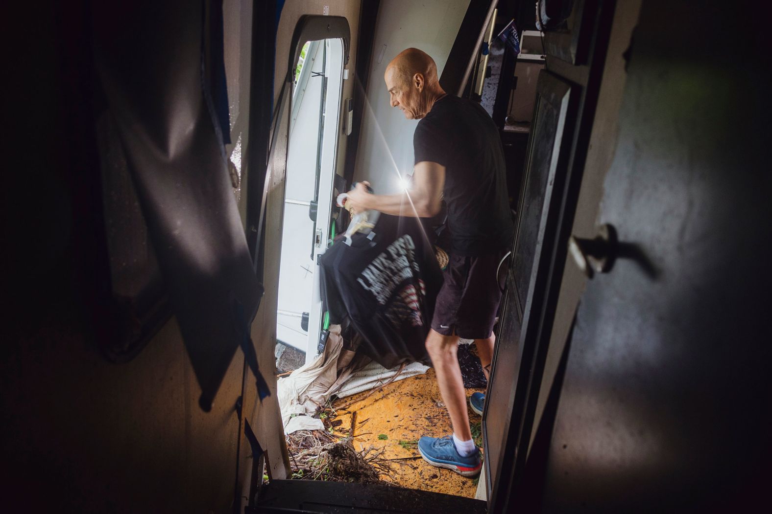 Thomas Rux, a resident of Riverside RV Park in Ingram, looks through the wreckage of his RV that was swept away by floodwaters.