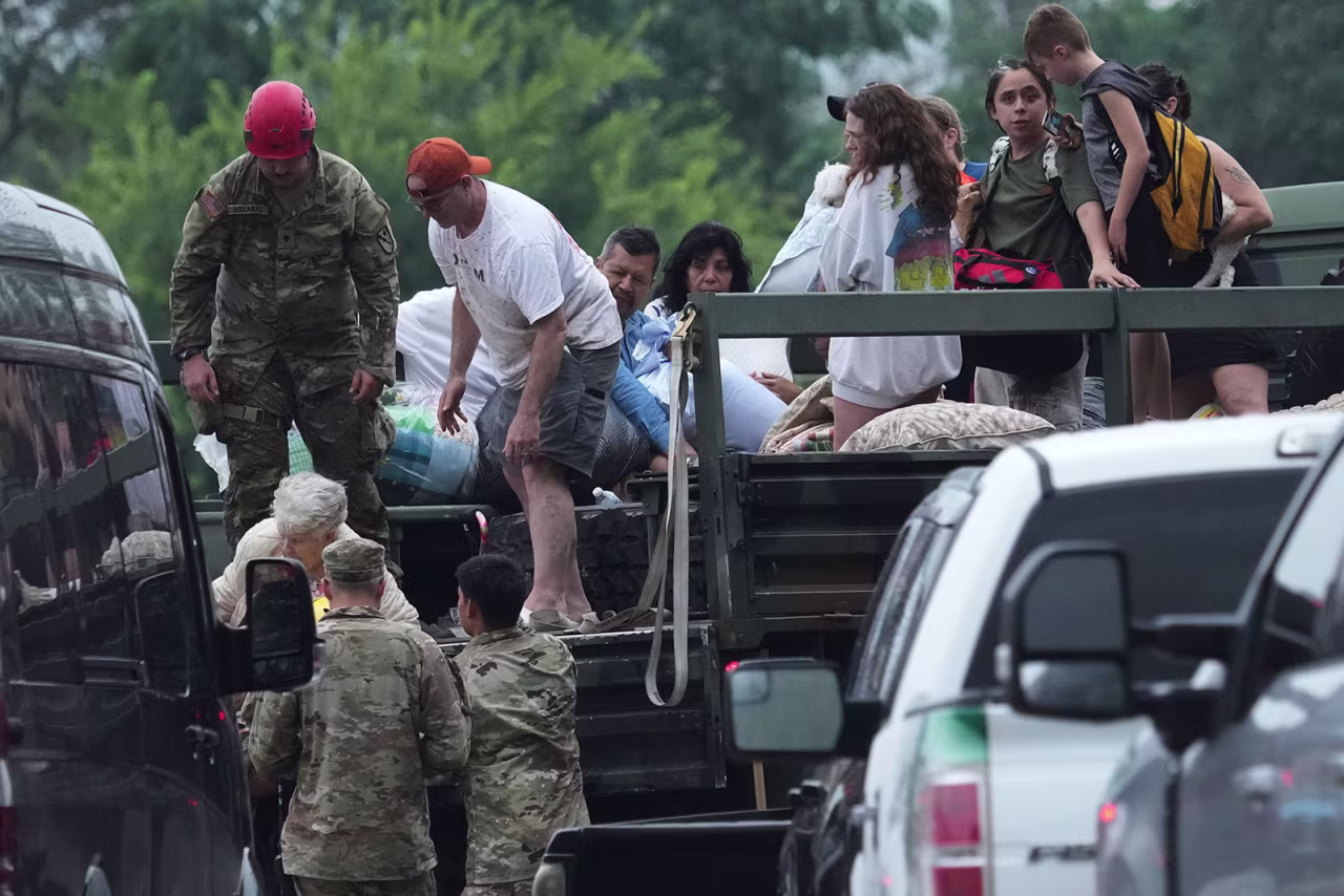 First responders deliver people to a reunification center in Ingram, Texas, on Friday, after flash flooding in the area.