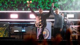 Liam Gallagher, left, holds the hand aloft of Noel Gallagher from the band Oasis as they perform during their reunion concert on Friday, July 4, 2025, in Cardiff.