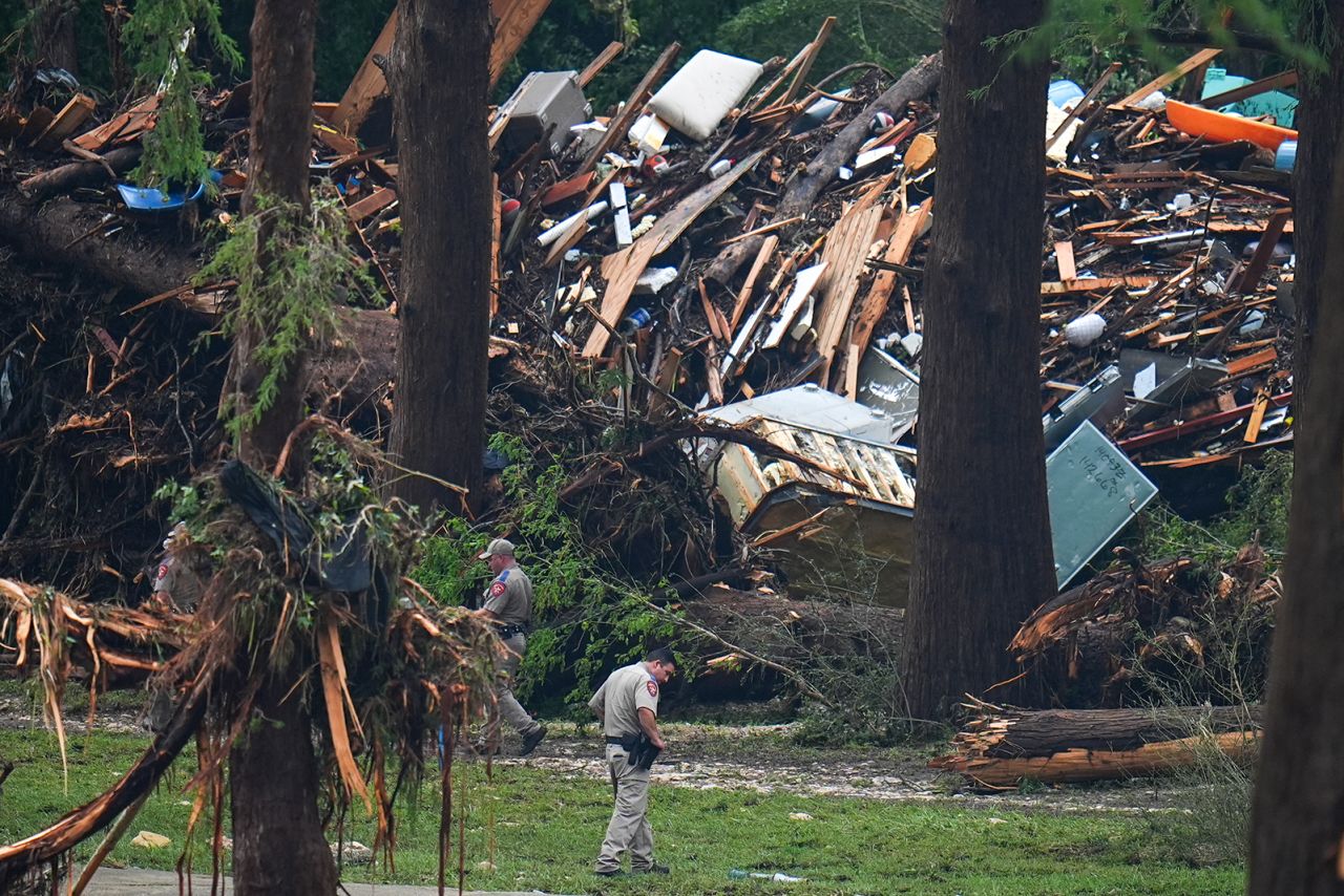 Officials comb through the banks of the Guadalupe River after a flash flood swept through the area in Hunt, Texas on Saturday.