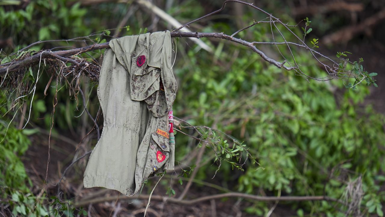 An article of clothing displays patches while resting on a tree across the Guadalupe River from Camp Mystic after a flash flood swept through the area Saturday, July 5, 2025, in Hunt, Texas.