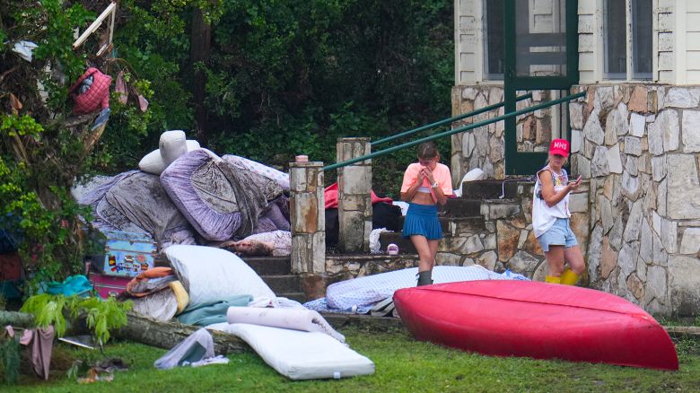 A person reacts while looking at the belongings outside sleeping quarters at Camp Mystic along the banks of the Guadalupe River after a flash flood swept through the area on Sunday, July 6, 2025, in Hunt, Texas.