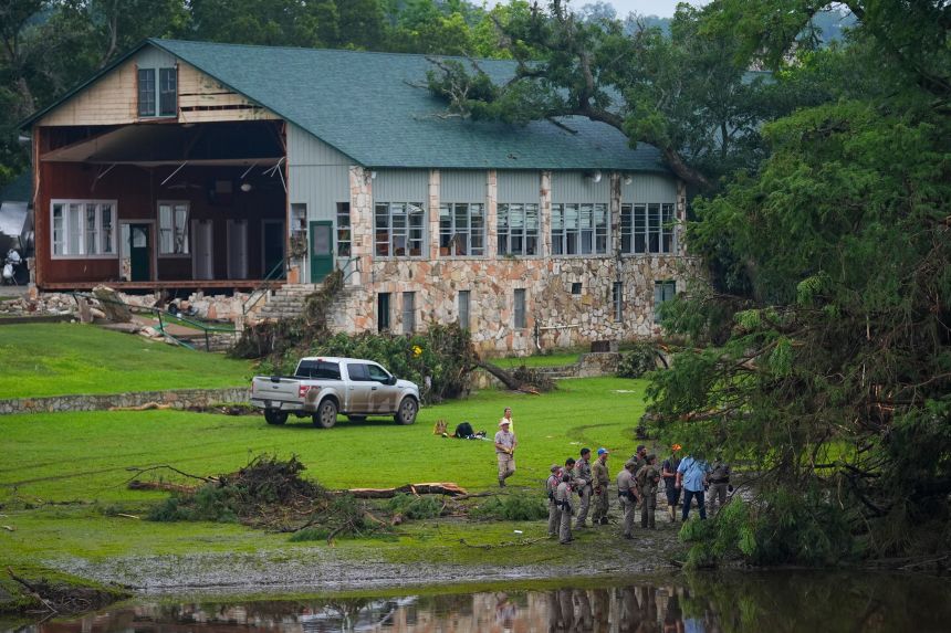 Officials search on the grounds of Camp Mystic on Sunday in Hunt, Texas.