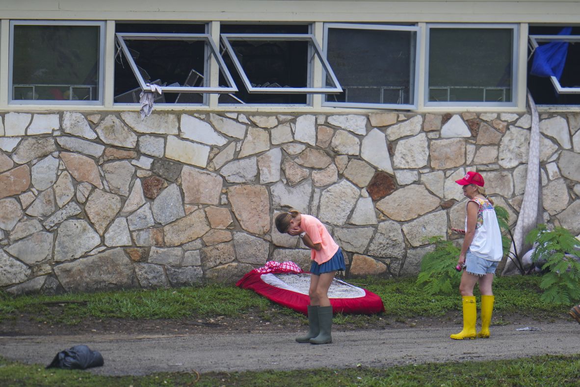 People react as they inspect an area outside Camp Mystic's sleeping quarters on Sunday.