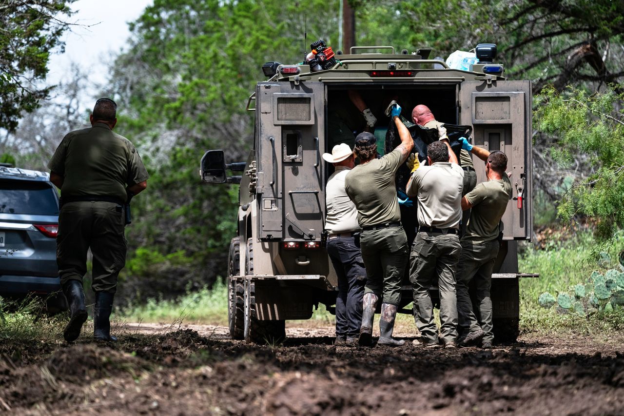 Texas Department of Public Safety Troopers load a recovered body into the back of a vehicle near the Guadalupe River on Monday.