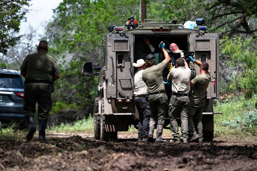 Texas Department of Public Safety personnel load a recovered body Monday into the back of a vehicle near the Guadalupe River in Ingram, Texas.