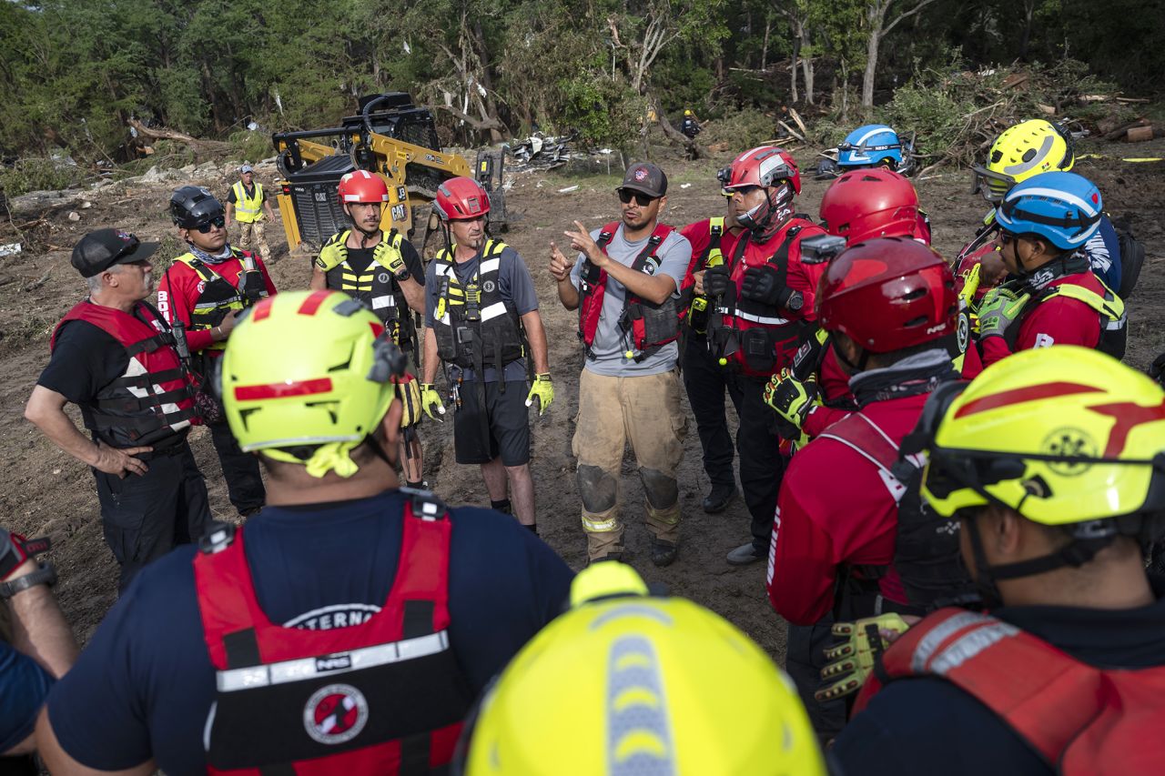 A crew of firefighters from Ciudad Acuna, Mexico, gather for a briefing as they aid in search and rescue efforts near the Guadalupe River, Texas, on Monday.