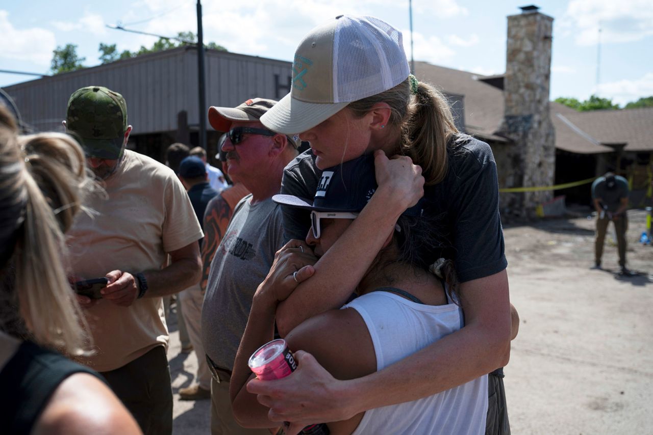 Volunteers helping in search and recovery efforts embrace during a press conference on Tuesday, in Hunt, Texas.