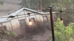 In this image taken from video, a house is carried away by flash flooding behind a house in Ruidoso, New Mexcio, on Tuesday, July 8, 2025.