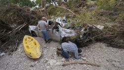  Kevin Scott, Danny LeBourgeois and Lincoln Edwards search for Aiden Heartfield, who went camping with friends and is missing,  around a damaged truck along the Guadalupe River after flooding in Kerrville, Texas on Wednesday , July 9, 2025. (AP Photo/Gerald Herbert)