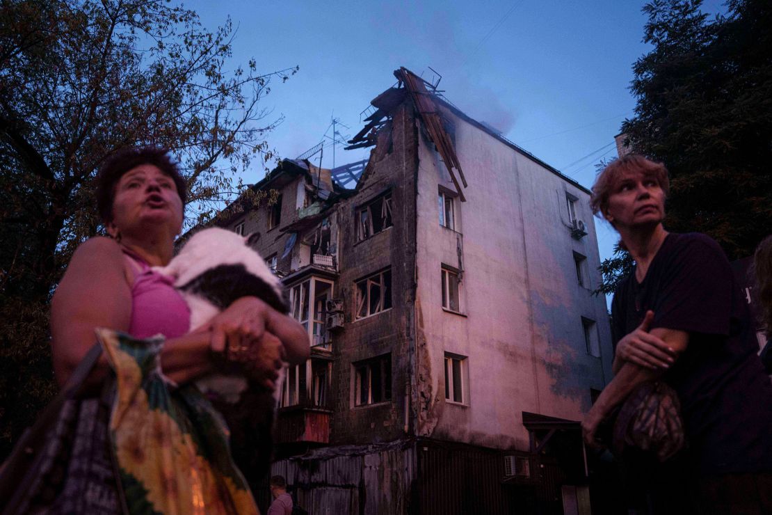 Residents stand outside of their damaged house in Kyiv, following a Russian strike on Thursday.