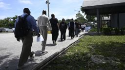 Job seekers walk in line to a job fair at the Central Florida Fairgrounds attended by employers looking to fill openings on July 10 in Orlando.