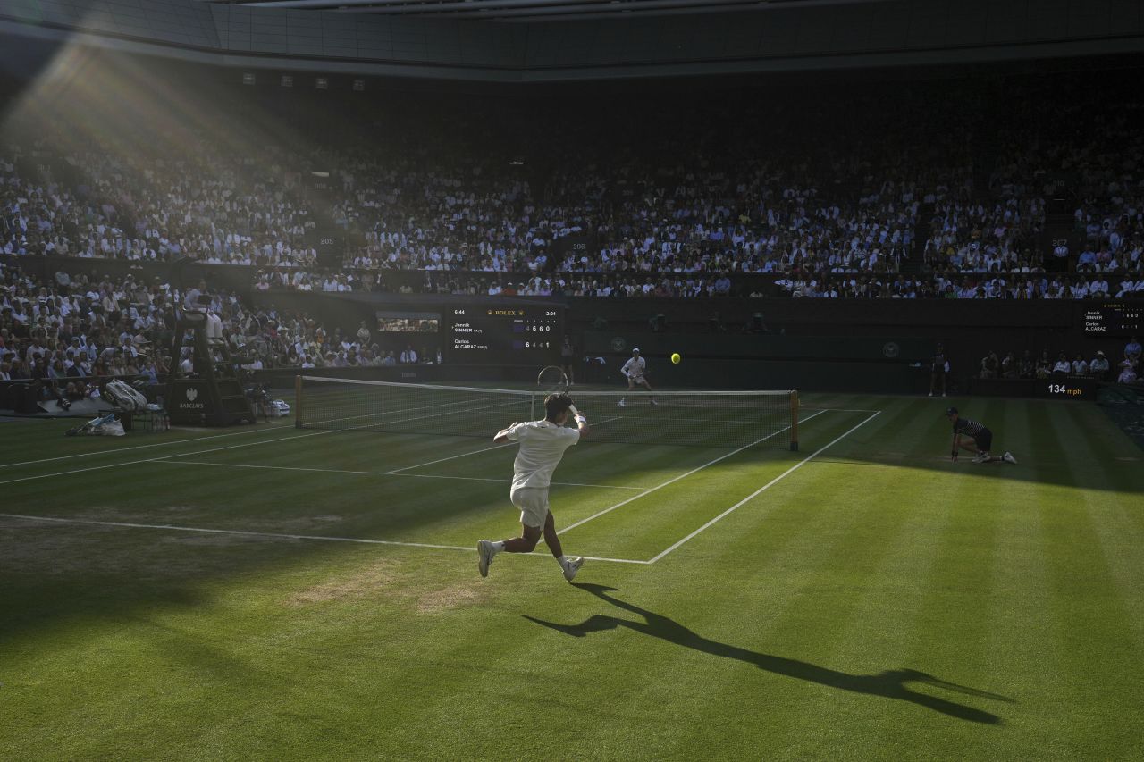 Shadows fall on Centre Court as Carlos Alcaraz, foreground, and Jannik Sinner compete in the final.