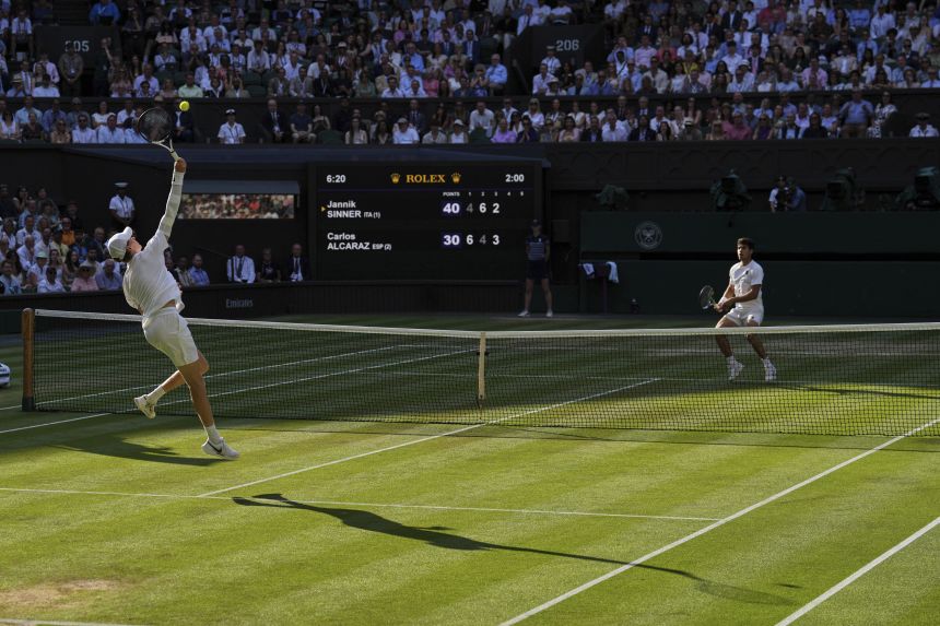 Jannik Sinner hits a smash during his Wimbledon final with Carlos Alcaraz in July.